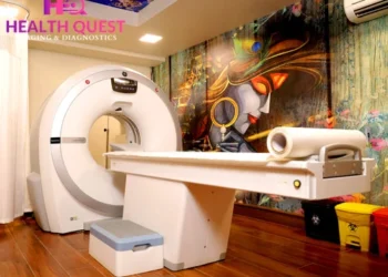 Modern CT scan room at Health Quest Imaging & Diagnostics featuring a state-of-the-art CT scanner, patient table, wooden flooring, and artistic wall mural for a comfortable diagnostic environment.