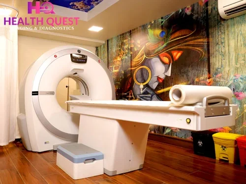 Modern CT scan room at Health Quest Imaging & Diagnostics featuring a state-of-the-art CT scanner, patient table, wooden flooring, and artistic wall mural for a comfortable diagnostic environment.